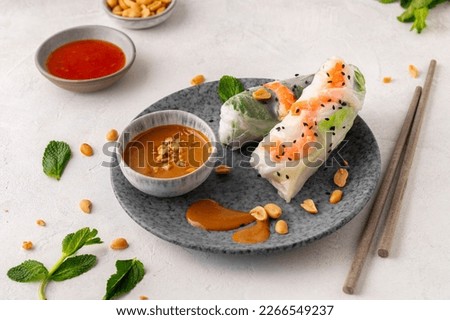 Summer rolls with fresh vegetables and shrimps and peanut sauce. Vietnamese appetizer. Salad spring rolls with prawns. Healthy food concept