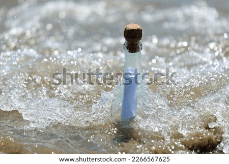 bottle of glass with secret message inside and waves of ocean