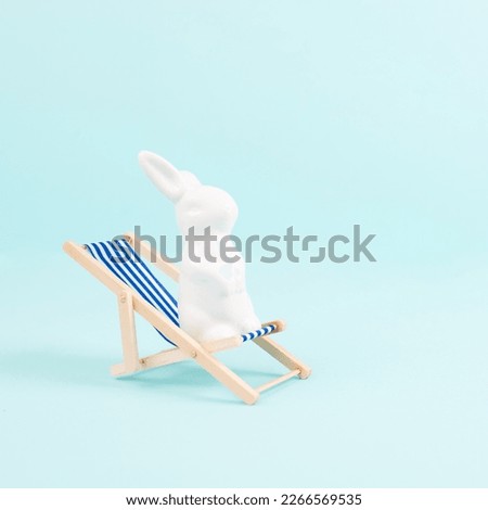 Bunny or rabbit sitting on lounge chair, easter holiday, vacation by the sea