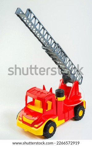 Toy multi-colored plastic fire truck on a white background.