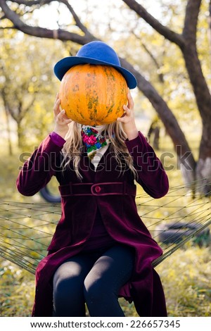 portrait of holding pumpkin elegant beautiful blond young hipster woman having fun happy smiling and looking at camera on autumn copy space outdoors background