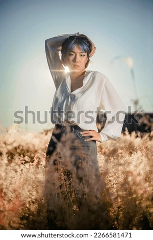 Beautiful asian young colorful hair lady at the outdoors flowered field.