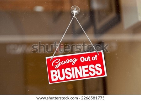 Red sign hanging at the glass door of a shop saying: "Going out of business". Royalty-Free Stock Photo #2266581775