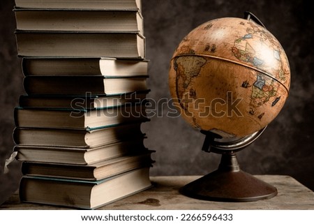Vintage books with globe on old wooden crate box background