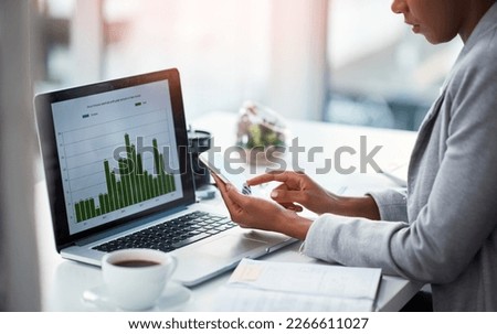 An accountant working on growth, tax review or expenses of a company with graphs or charts on a laptop screen. Closeup of a financial advisor typing on a phone while analyzing business statistics Royalty-Free Stock Photo #2266611027