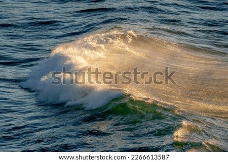 Waves with gold sparkles from the sunset golden hour 