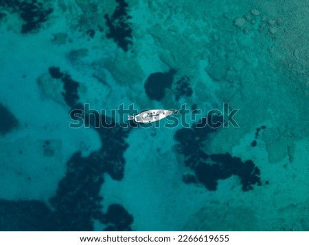 Top down sailboat in the clean water sea with a coral. Aerial view, minimalistic shot