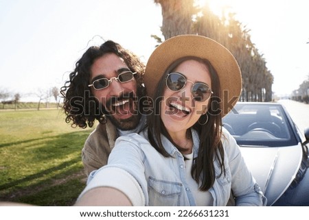 Selfie happy couple friends with big smiles. Young people taking photo of summer trip. Man and woman posing excitedly outside of car. Concept of youth, relationship, holidays and vacation.