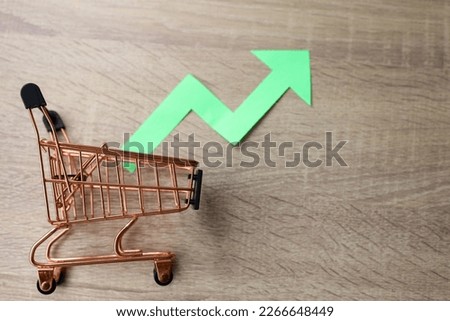 Green arrow of a chart on shopping trolley. Crisis and rising commodity prices concept. Royalty-Free Stock Photo #2266648449
