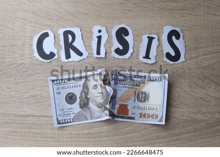 Crisis lettering with teared dollar banknote. Financial crisis concept.  Royalty-Free Stock Photo #2266648475