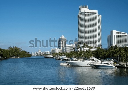 Yachts docking at the Indian Creek before the rows of luxury hotels in Miami beach on a sunny day