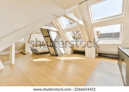 an attic style room with wood floors and skylights on the roof, looking towards the living area to the bedroom Royalty-Free Stock Photo #2266654421