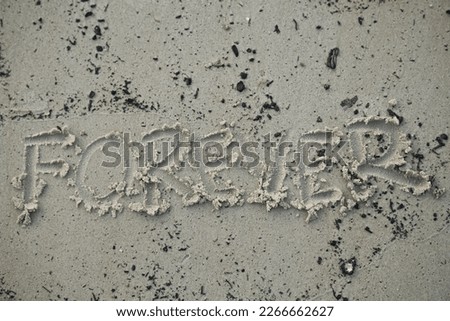 Word Forever written on the sand at a beach