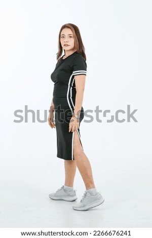 Portrait isolated cutout full body studio shot Asian fit strong female athlete model in black white stripes sport wears dress with running shoes sneakers standing smiling posing on white background.