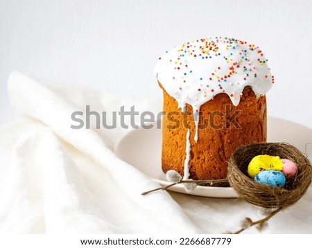 kulich easter holiday pastry, decoreted easter cake, homemade dessert, festive holiday easter treat healthy meal food on white table with colored eggs. Copy space, side view, food background card.
