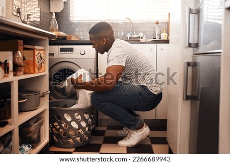 I always do laundry on the weekend. Shot of a man doing the laundry at home. Royalty-Free Stock Photo #2266689943