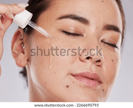 Face, eyes closed and skincare of woman with serum in studio isolated on a gray background. Dermatology skin, beauty cosmetics and female model apply hyaluronic acid, essential oil or retinol product Royalty-Free Stock Photo #2266690793