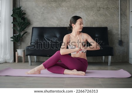 Young asian woman doing yoga in living room, yoga poses for exercise and meditation, doing yoga postures for body and mind balance, exercise for a healthy body. Yoga concept.