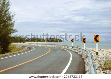 Curve road beside the sea with coconut tree
