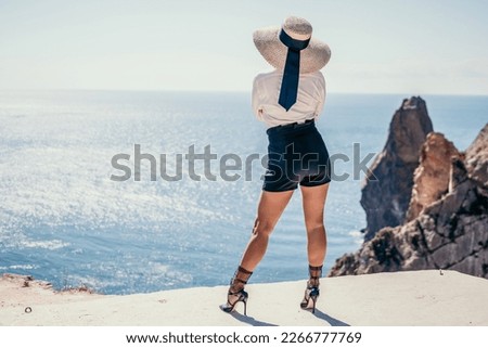Woman sea hat. Business woman in yellow hat freelancer working over blue sea beach. Girl relieves stress from work. Freelance, digital nomad, travel and holidays concept