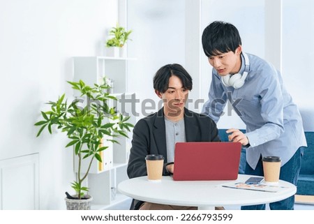 Young casual asian men group looking at laptop PC together. Video editor. Desk top music. DTM. Royalty-Free Stock Photo #2266793599