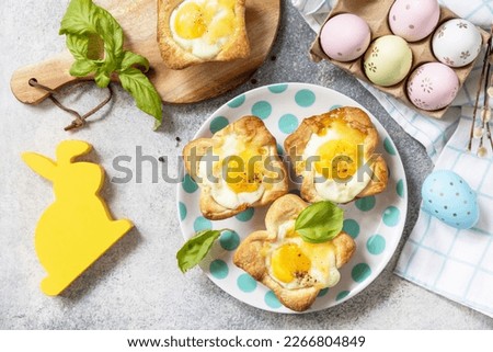 Easter breakfast idea. Scrambled eggs in puff pastry with cheese and bacon on a stone background. View from above. 
