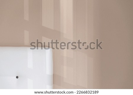 Minimalist wall detail in pastel tones with light coming in from the window. Play of light and shadow. Background for wallpaper, for writing. Copy space