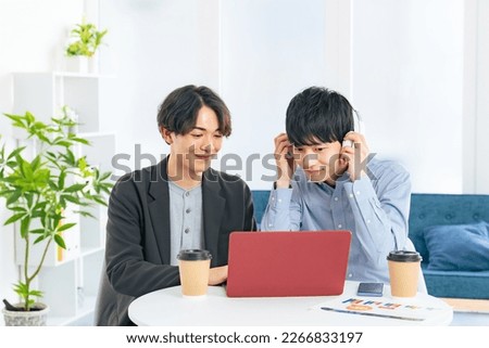 Young casual asian men group looking at laptop PC together. Video editor. Desk top music. DTM. Royalty-Free Stock Photo #2266833197