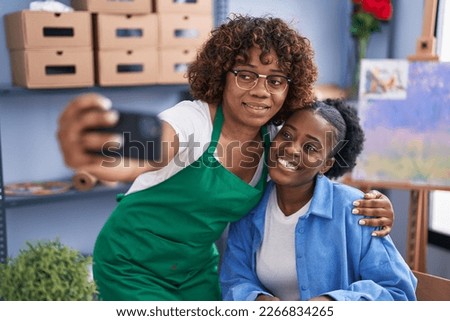 African american women teacher and student artist make selfie by smartphone at art studio
