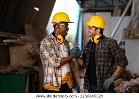 Two carpenters making handshake to collaborate teamwork for building handmade furniture, team agrees to work together for making wood crafts at workshop. Joiner, craftsman, handyman,  timber, woodman Royalty-Free Stock Photo #2266845329