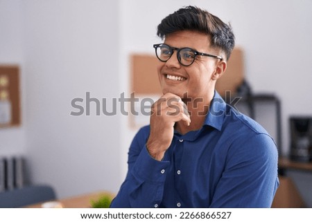 Young hispanic man business worker smiling confident at office Royalty-Free Stock Photo #2266866527