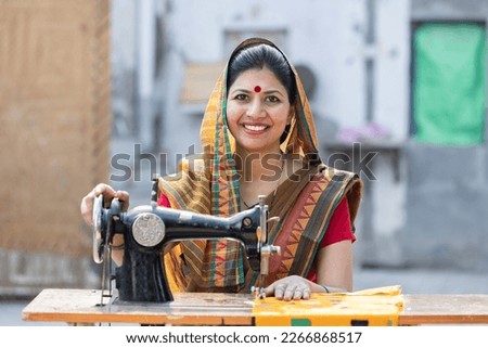 Rural woman sewing clothes with sewing machine at home.