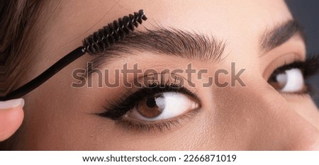 Close up eyebrows with eyebrow brush. Care for brows, eyebrows lamination. Brow procedures. Long eyelashes, eyebrows, macro. Royalty-Free Stock Photo #2266871019