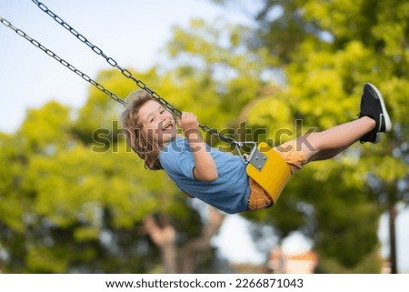 Little kid swinging portrait. Adorable child having fun on a swing on summer day. Royalty-Free Stock Photo #2266871043