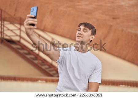 Young caucasian man smiling confident making selfie by the smartphone at street