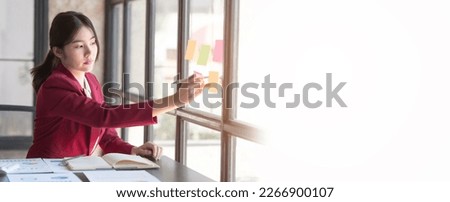 Hard working of asian people bookkeepers working with balance sheet and taxation, company quarterly reports of accounting and marketing. write on sticky notes.
