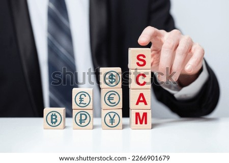 Wooden blocks with word scam and currency icons. Business fraud, scam, crime concept