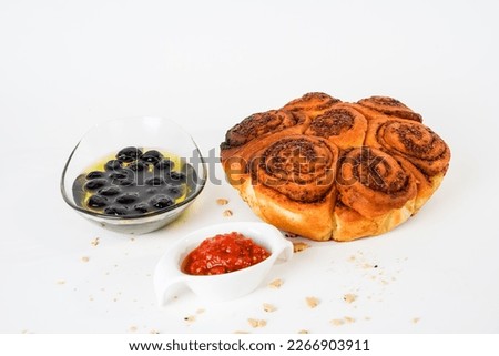 Salty bread with walnut poppy sesame, marinated ripe black olives and chili tomato sauce isolated on white background.