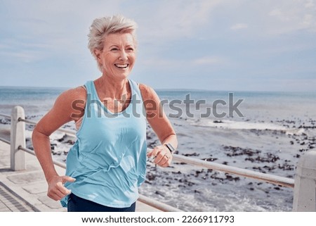 Senior woman, fitness and running at beach promenade, sky mockup and energy of health, wellness and workout. Elderly female, exercise and runner at ocean for happy sports, cardio training or marathon Royalty-Free Stock Photo #2266911793