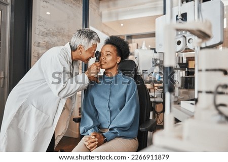 Doctor, vision or black woman in eye exam consultation or assessment for eyesight at optometrist office. Mature or senior optician helping a customer testing or checking iris or retina visual health Royalty-Free Stock Photo #2266911879