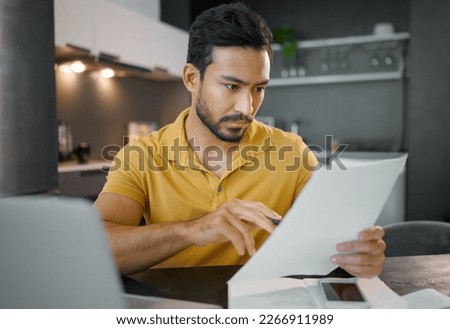 Businessman, home office and documents by laptop in kitchen for focus, small business growth and opportunity. Digital entrepreneur, business owner and reading with contract, proposal and paperwork Royalty-Free Stock Photo #2266911989