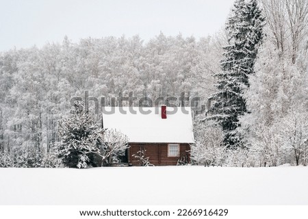 Wooden house in snow fairy forest. Winter scenery with small cottage surrounded by trees covered with snow and frost.  Royalty-Free Stock Photo #2266916429
