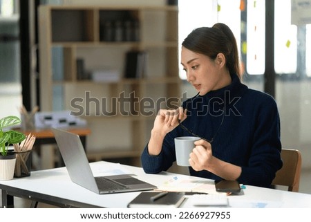 Businesswoman using laptop at cafe while drinking coffee, Relaxing holiday concept.