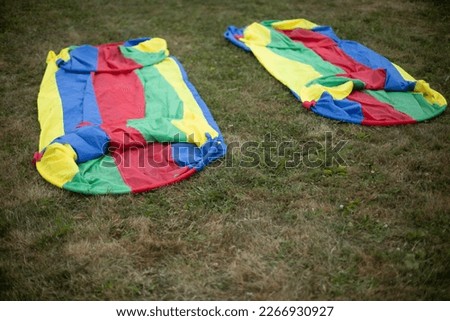 Equipment for sports game. Colored fabric. Folded tunnel for competitions. Details of game on lawn.