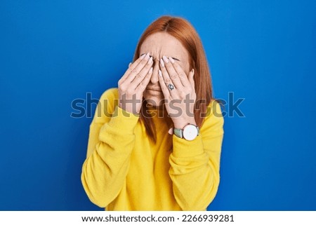Young woman standing over blue background rubbing eyes for fatigue and headache, sleepy and tired expression. vision problem 