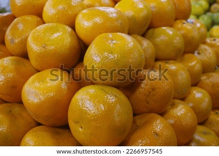 stacks of fresh oranges neatly arranged in the fruit shop.