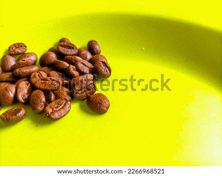 Closeup of Coffee beans isolated on a green plate with copy space available for illustration editorial and background. Landscape. High Angle View.