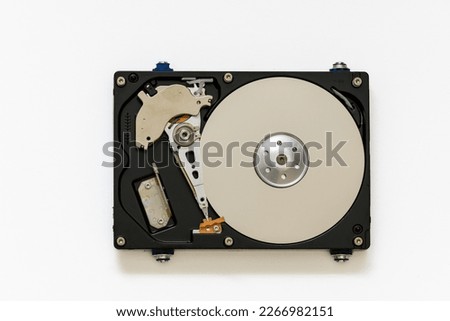 Disassembled hard drive on a white background, isolated. The electronic insides of the information storage device, the reading head. Royalty-Free Stock Photo #2266982151