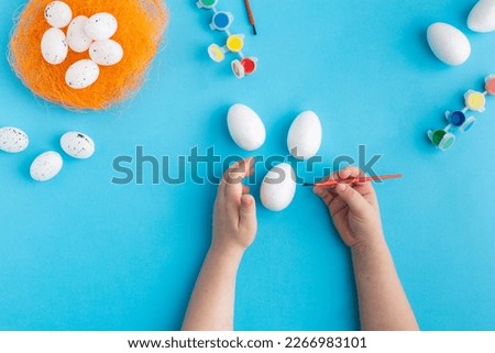 white eggs ready to be painted easter concept baby hands