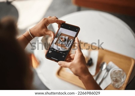 Hands snapping food before eating with mobile phone. Hand taking photo of dessert food with smartphone. Woman using smartphone taking digital picture Top view of dessert on screen
